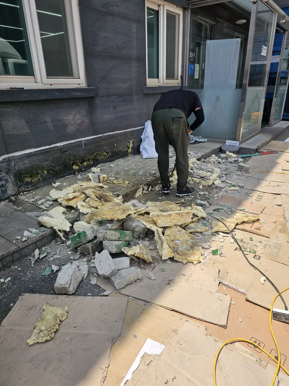 인공연못 재시공 철거 중 작업자가 잔해를 정리하는 모습