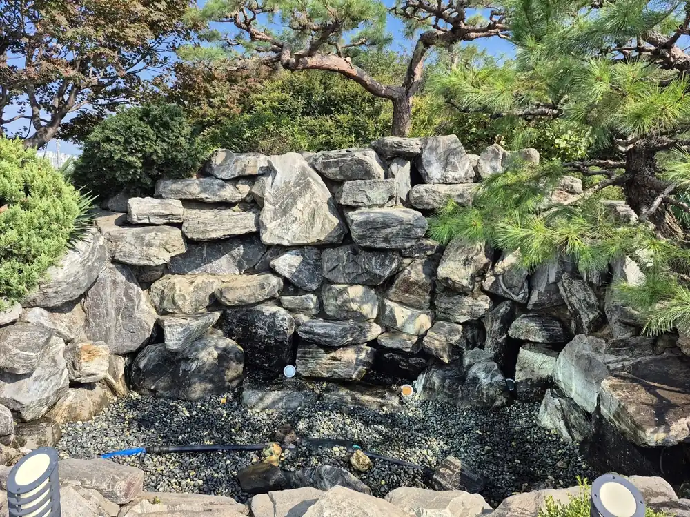 오산 연못 수리 진행 후 암석 폭포 아래 정리된 연못 바닥